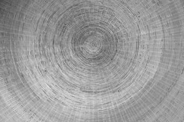 Abstract detail in black and white of a bronze base made up of concentric circles and drawn inside each other.