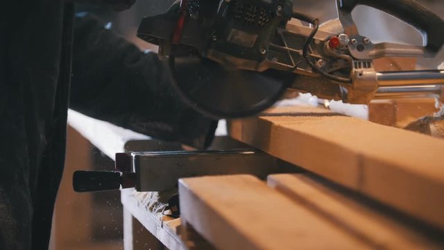 Circular saw sawing a wooden board on joinery