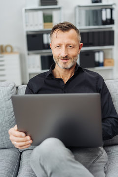 Man sitting at home browsing on a laptop