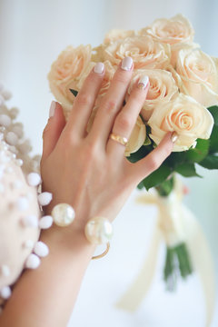a bouquet of white roses in hands of bride