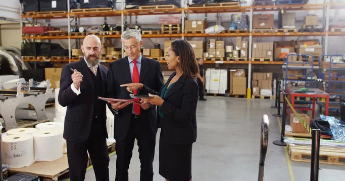 4K Management team in warehouse checking inventory & looking over the figures. Slow motion.