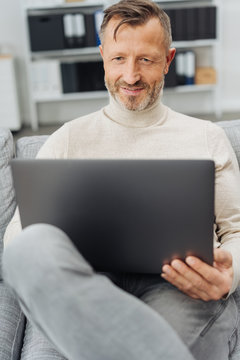 Man sitting relaxing at home with his laptop
