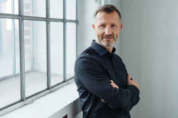 Middle-aged man standing with folded arms