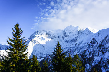 Beautiful landscape of snowy mountain view with sprouce of pine tress in Bellvue Saint-Gervais-les-Bains. Alps mountain top near Mont Blanc. Famoust place for winter sport like skiing with family