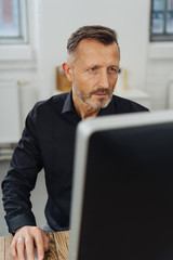 Concerned businessman staring at his monitor