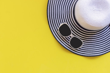 ummer Fashion woman big hat and accessories in the beach. Tropical sea.Unusual top view, yellow background. Summer Concept.