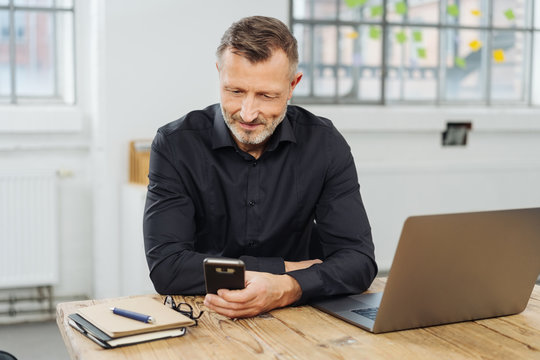 Businessman sitting checking his mobile phone