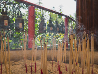 Fototapeta premium Incense sticks on joss stick pot are burning and smoke use for pay respect to the Buddha.