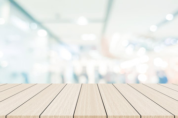 abstract blur glowing light color of interior department store background with modern wood panel flooring for promote content , product on display