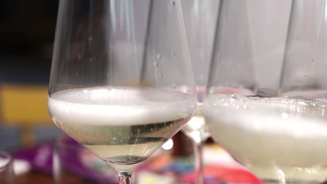 A glass of prosecco is filled by producing bubbles and foam. Sparkling white wine in a glass to toast to a celebration