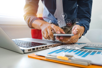 close up of businessman working with smart phone and laptop and digital tablet computer in modern office with virtual icon diagram
