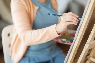 artist with brush painting at art studio