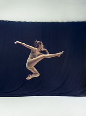 Young teen dancer ion white floor background.