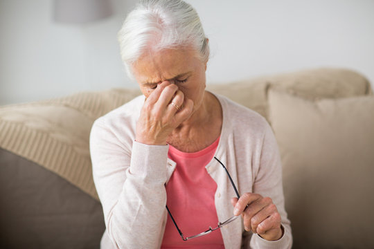 senior woman with glasses having headache at home