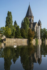 One white swan on the river near the ancient french castle in the summer day in Metz