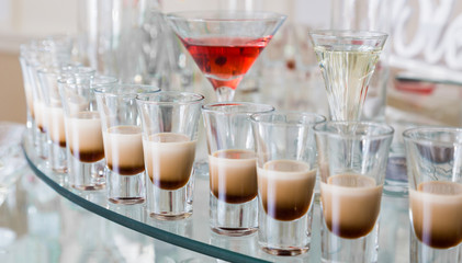 Alcoholic cocktails on a glass surface, banquet table.