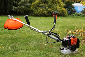 Brush cutter with leaf in autumn garden
