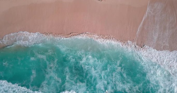 Hawaii Oahu drone aerial looking down stationary over crystal clear beach with surfer