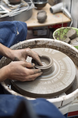 Artist makes clay pottery on a spin wheel
