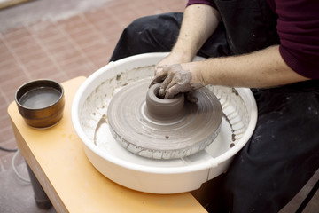 Artist makes clay pottery on a spin wheel