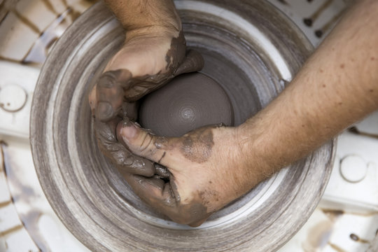 Artist makes clay pottery on a spin wheel