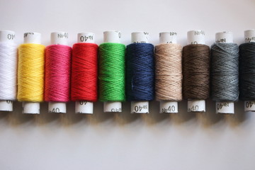Spools of colorful threads. Line of cotton threads. Needlework and sewing concept. Sewing and embroidery hobby background. 