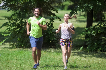 Fototapeta premium Young couple jogging at the green environment
