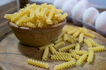 Italian fusilli pasta, raw food on wooden background.
