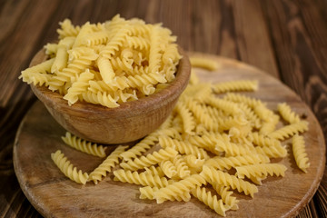 Italian fusilli pasta, raw food on wooden background.
