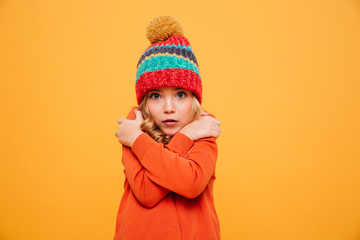 Young girl in sweater and hat having cold