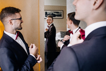 Three handsome male friends meet and speeking each other. Groomsman or best man greeting groom at wedding day.