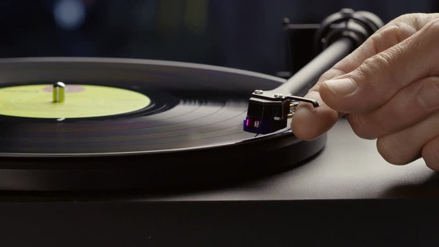 Hand laying needle on vinyl record