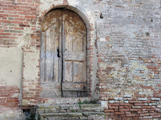 Old wooden door in old brick wall