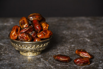 Dried raisins of grapes and dates in a medium-sized cup close-up shot
