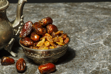 Dried raisins of grapes and dates in a medium-sized cup close-up shot
