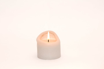 Fototapeta na wymiar Single burning candle against a white background