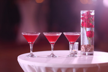 Cocktail glass and vase with red roses
