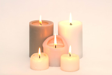 Fototapeta na wymiar Set of five burning candles against a white background