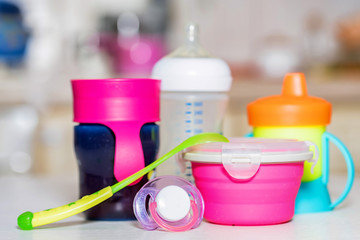 Bright plastic baby dishes on table
