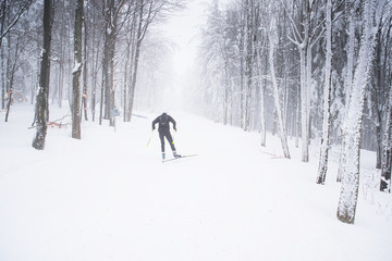 Panoramic view of male person cross-country skiing in beautiful nordic winter landscape in Scandinavia with blue sky and golden evening light at sunset, Europe