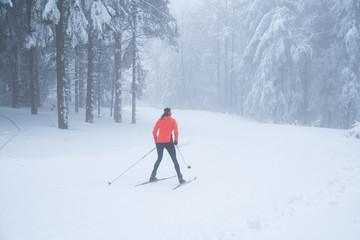 Woman ride cross country skiing in white winter nature