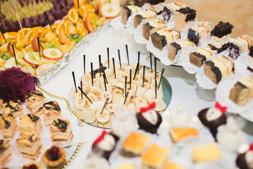 Delicious sweets on wedding candy buffet with desserts, cupcakes