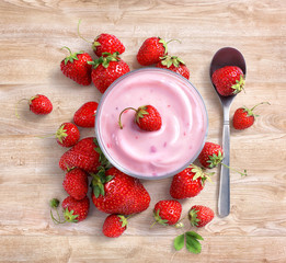 Yogurt with fresh strawberry on wooden background. Fruits diet concept. Top view, high resolution product.