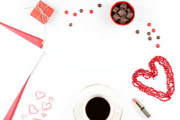 Coffee cup, sweets, lipstick, heart shape and giftbox on white background. Valentine's Day concept frame.