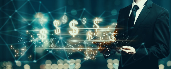 Dollars with businessman holding a tablet computer