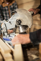 Electric hand saw and carpenters working