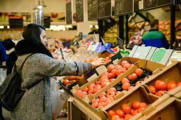 woman choose tomatos in the store