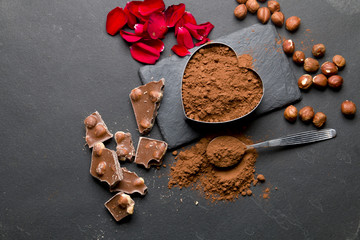 Pieces of chocolate and cocoa on a black stone background