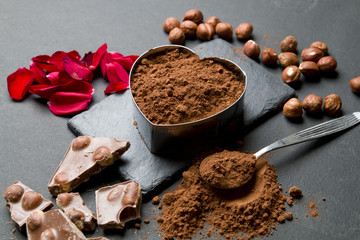 Pieces of chocolate and cocoa on a black stone background