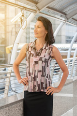 Middle aged professional woman smiling with walk way background.